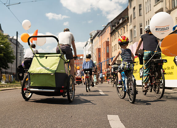 Familie bei Sternfahrt in Berlin Familie auf Rändern mit Fahrradanhänger auf städtischer Straße von hinten zu sehen